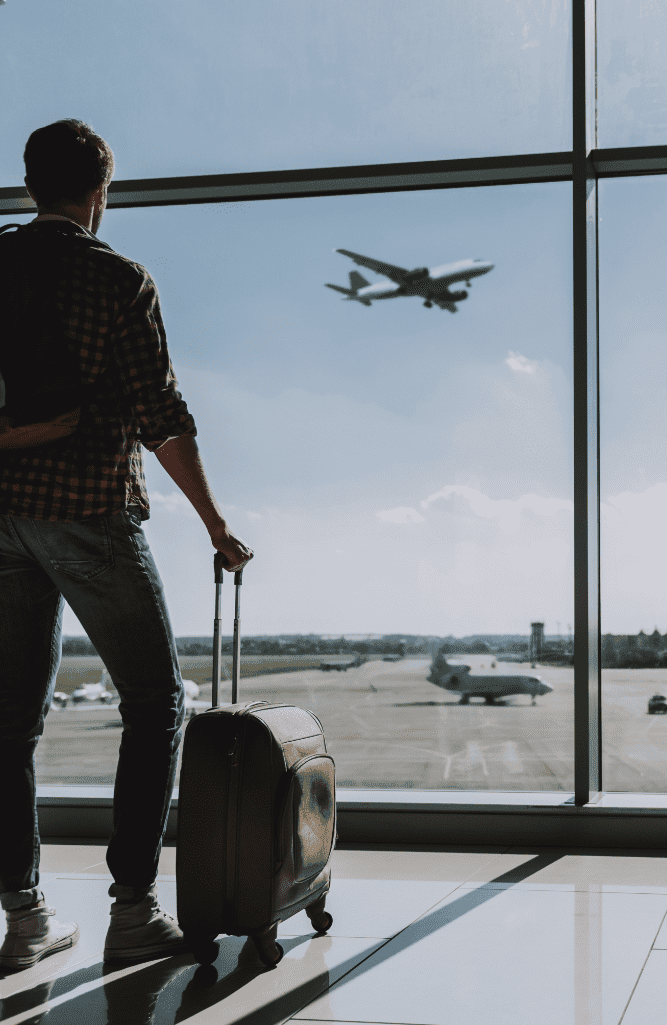 Man is watching plane flying from airport