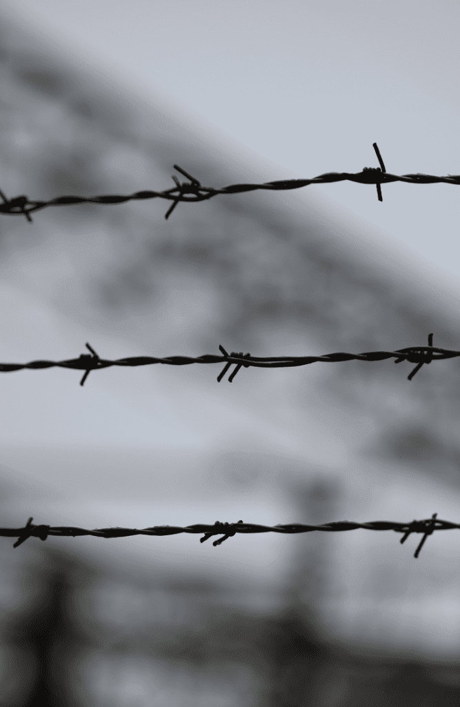barbed wire with the blurred background of a refugee camp 1
