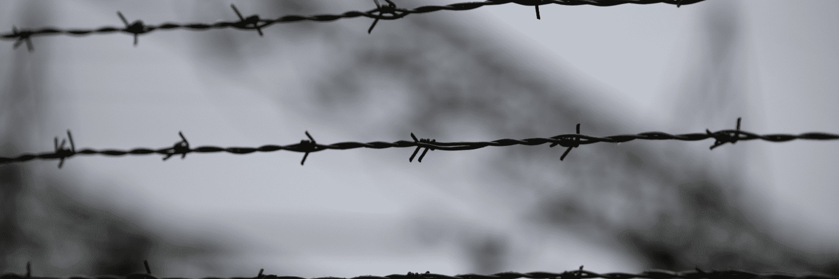 barbed wire with the blurred background of a refugee camp 2