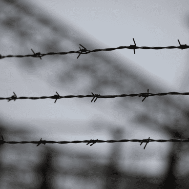 barbed wire with the blurred background of a refugee camp